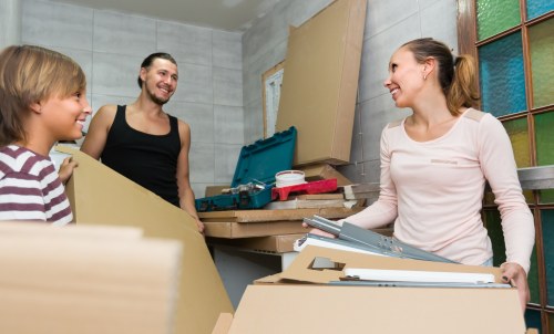 Removal team preparing furniture with safety equipment during a home move